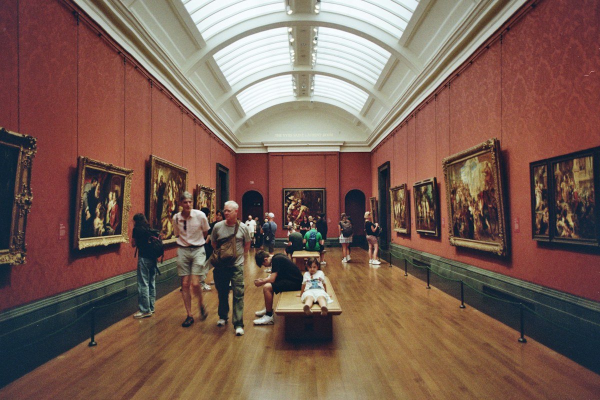 Visitors looking at paintings in an art gallery